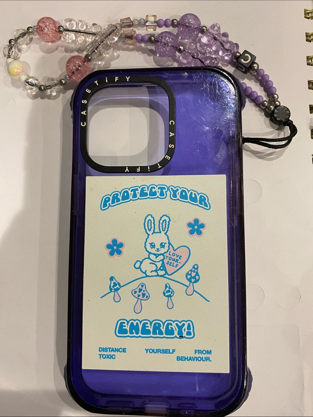 Casetify Purple Bunny 'Protect Your Energy' Phone Case iPhone 14 Pro with strap